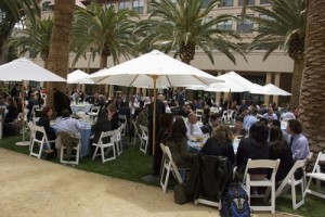 people sitting at tables under umbrellas outdoors